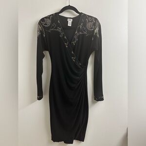 Black long-sleeve dress with gold and black studs along shoulders and V-neck.